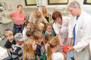 Dr. Annette Kehr, Oberärztin der Klinik für Kinderchirurgie, und Erzieherin Petra Germer zeigen den Vorschulkindern wie ein Gips angelegt wird. D41_0958